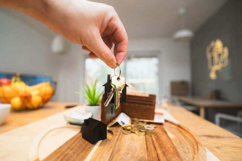 hand holding house keys blurred background
